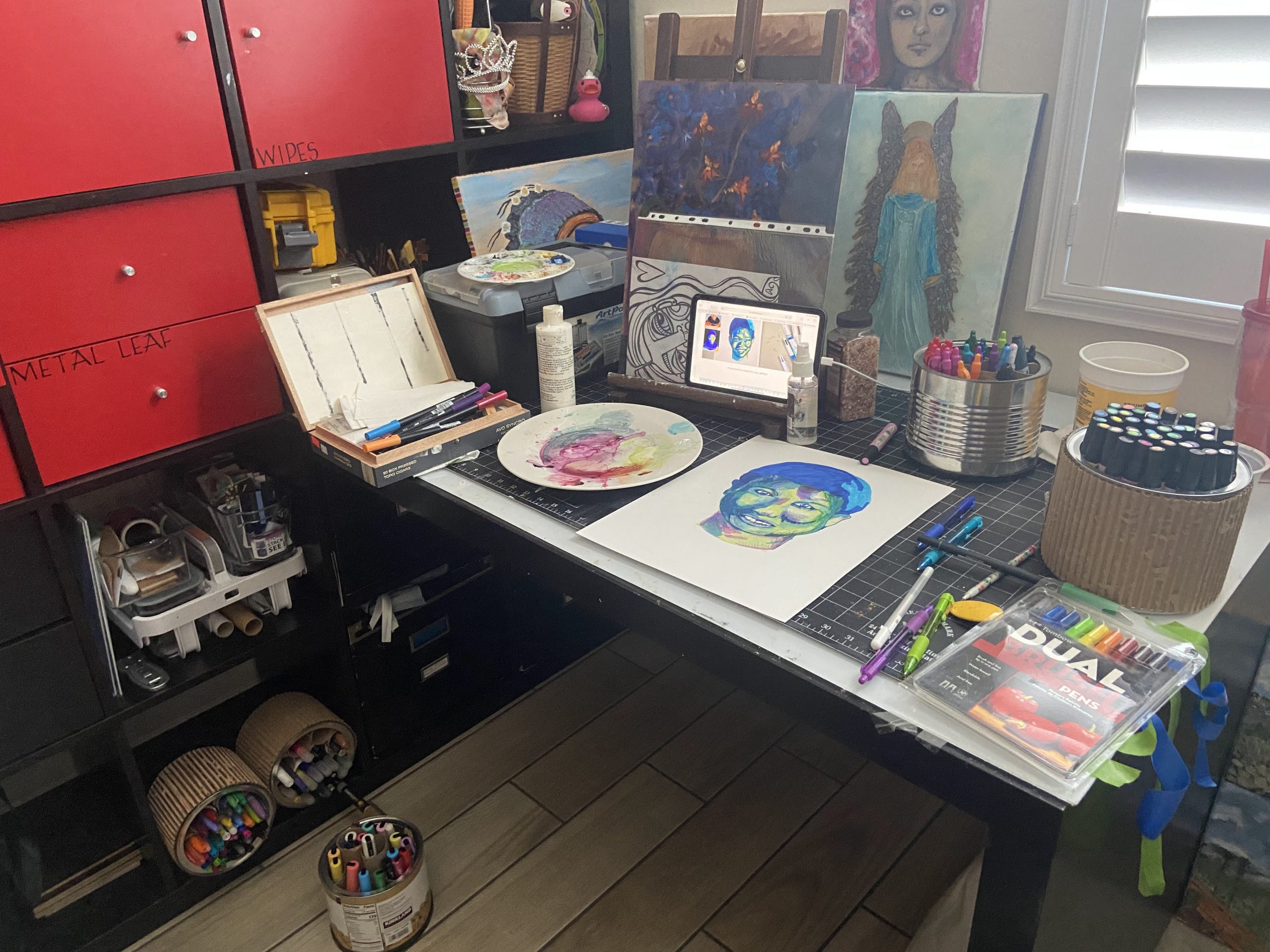 Art studio strewn about with works in progress and art supplies.
