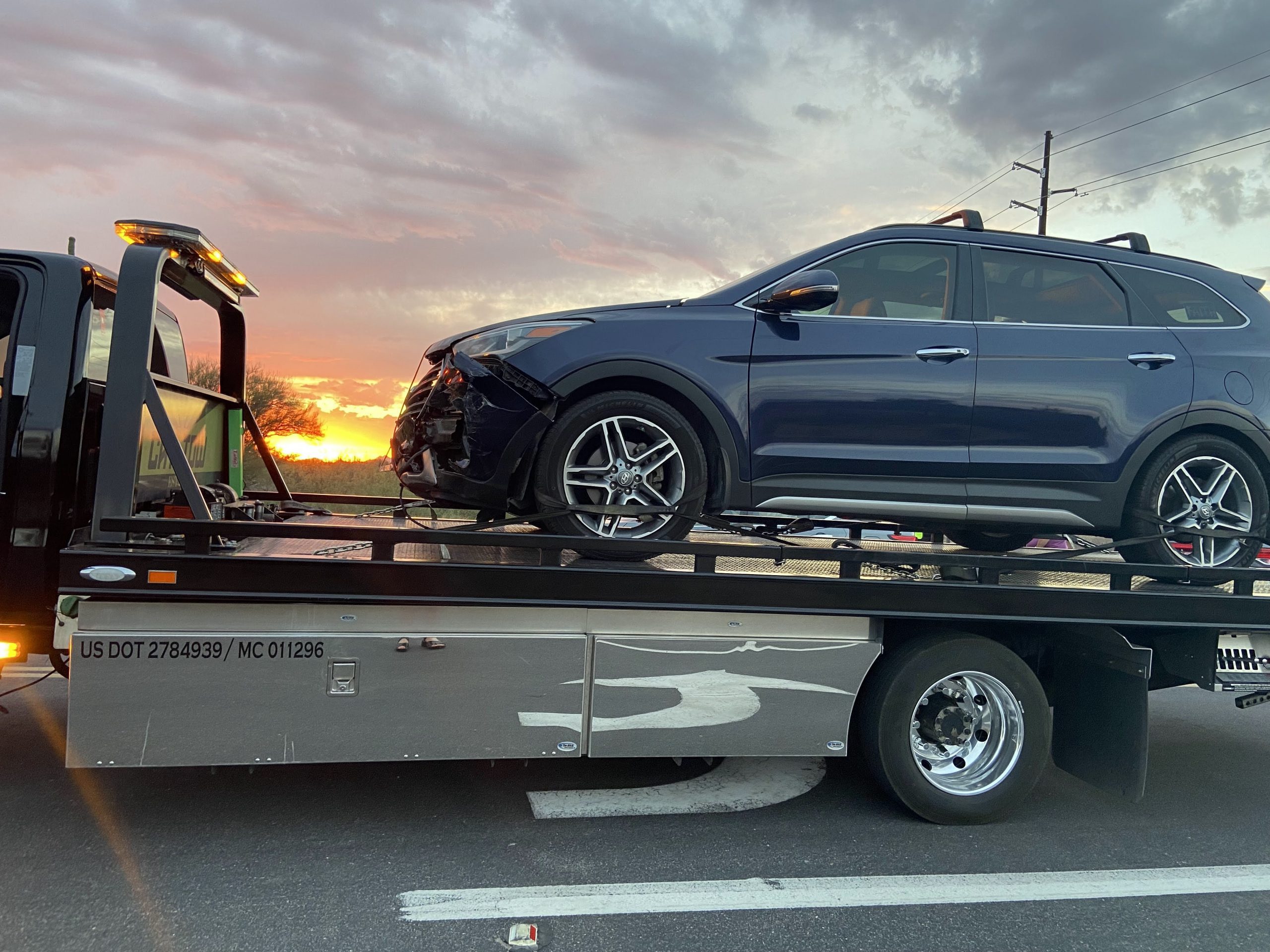 Wrecked automobile being loaded on a tow-truck. 