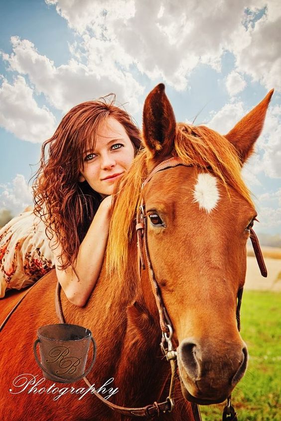 Photograph of a red-haired woman on a sorrel horse.