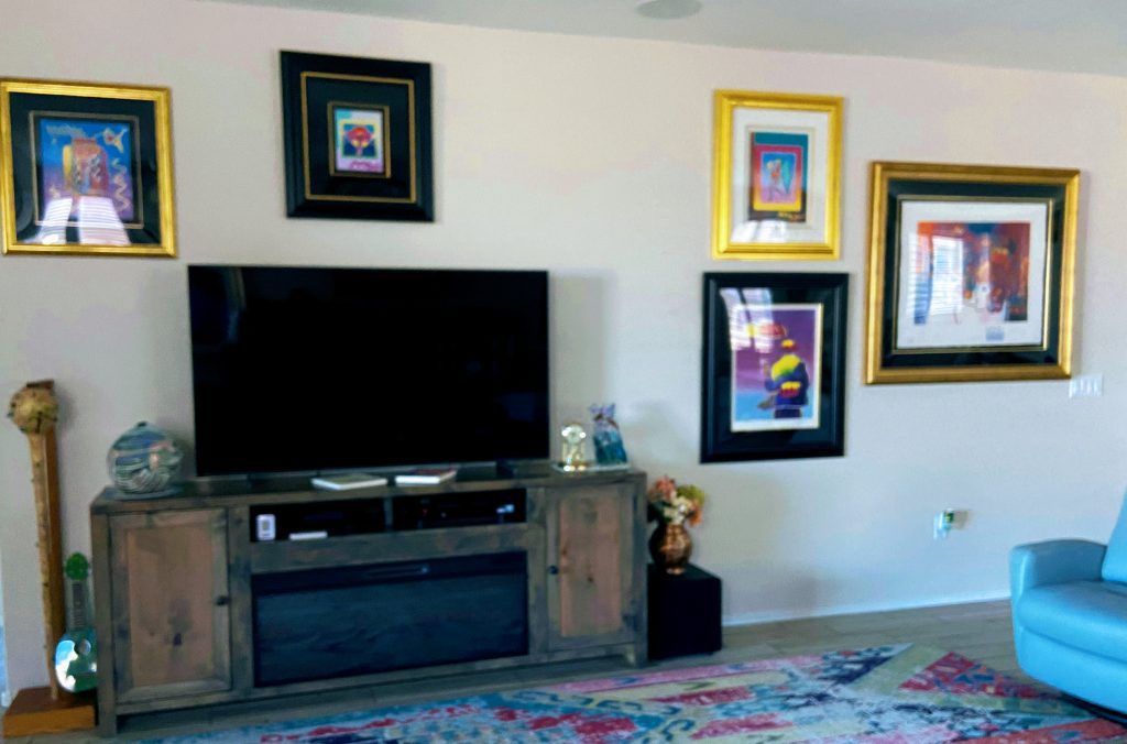 Photo of an interior wall decorated with Peter Max paintings.