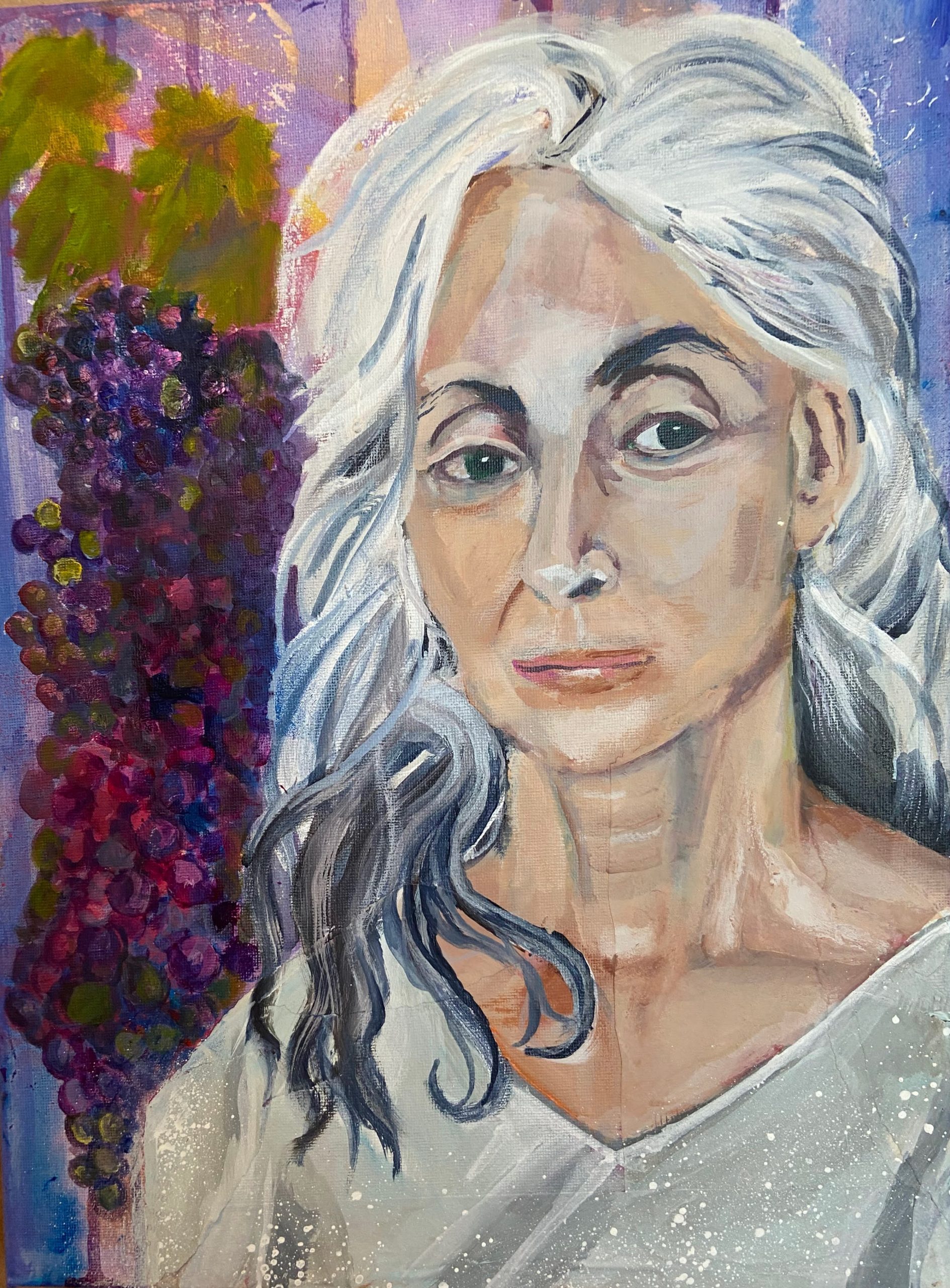 Portrait of a mature woman standing by a bunch of grapes. 