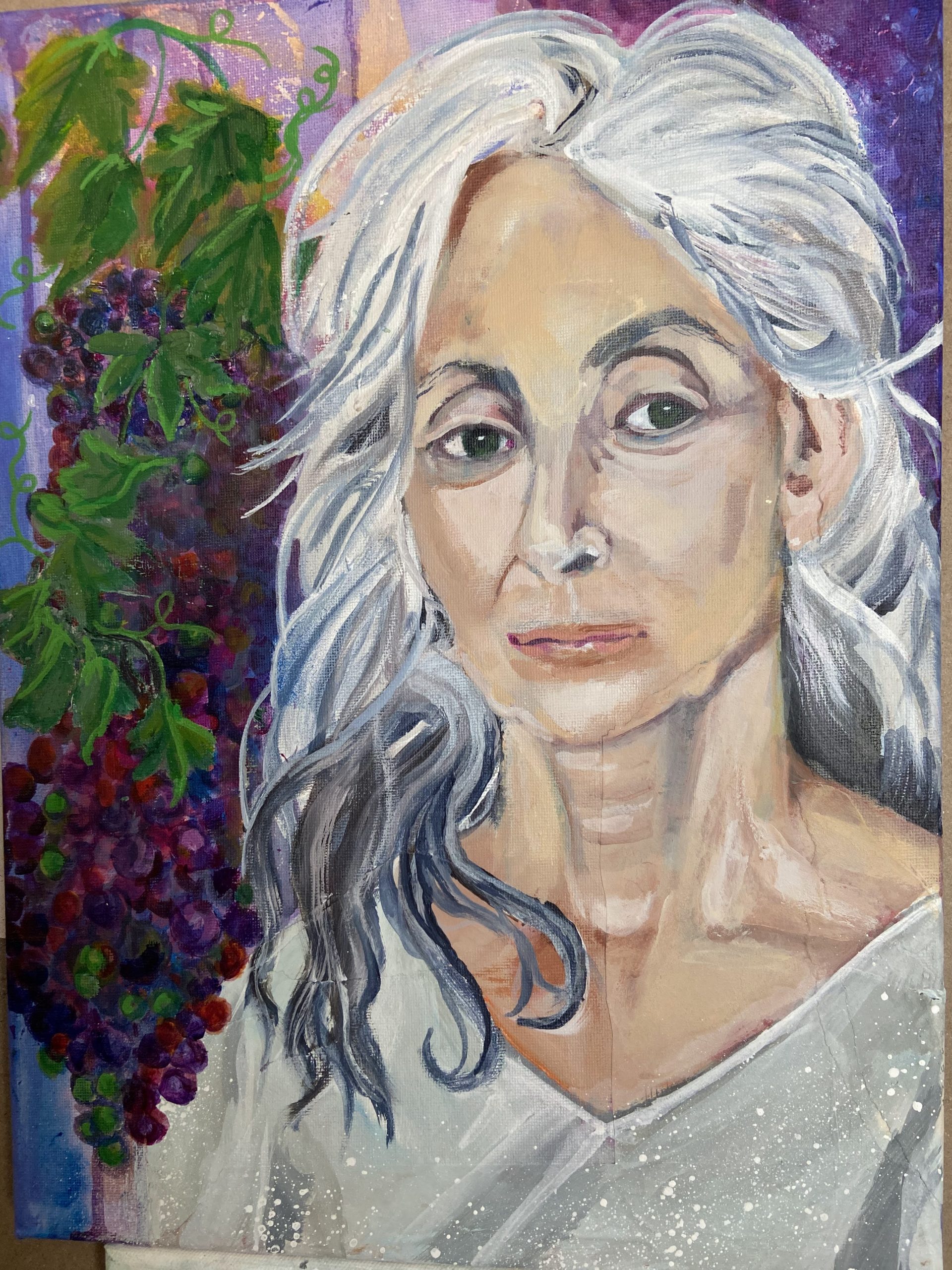 Portrait of a mature woman standing by a bunch of grapes. 